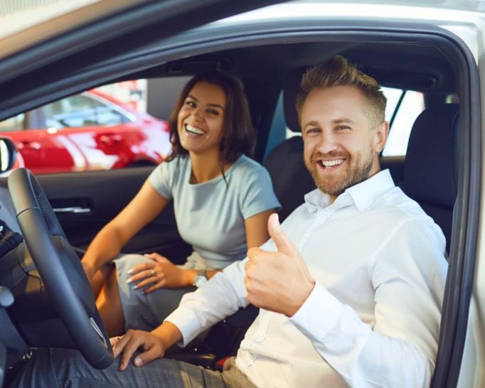 Prestige Notaries - A man and woman giving thumbs up in a car after mobile notary services.